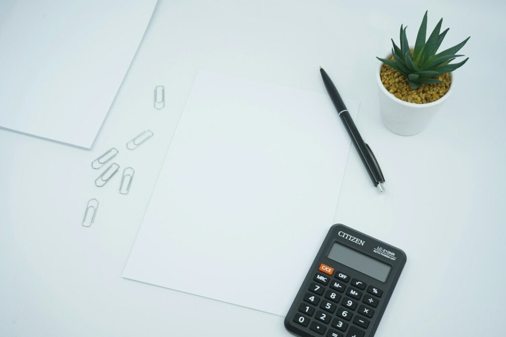 Bureau avec documents, stylo et calculatrice pour préparer une location courte durée