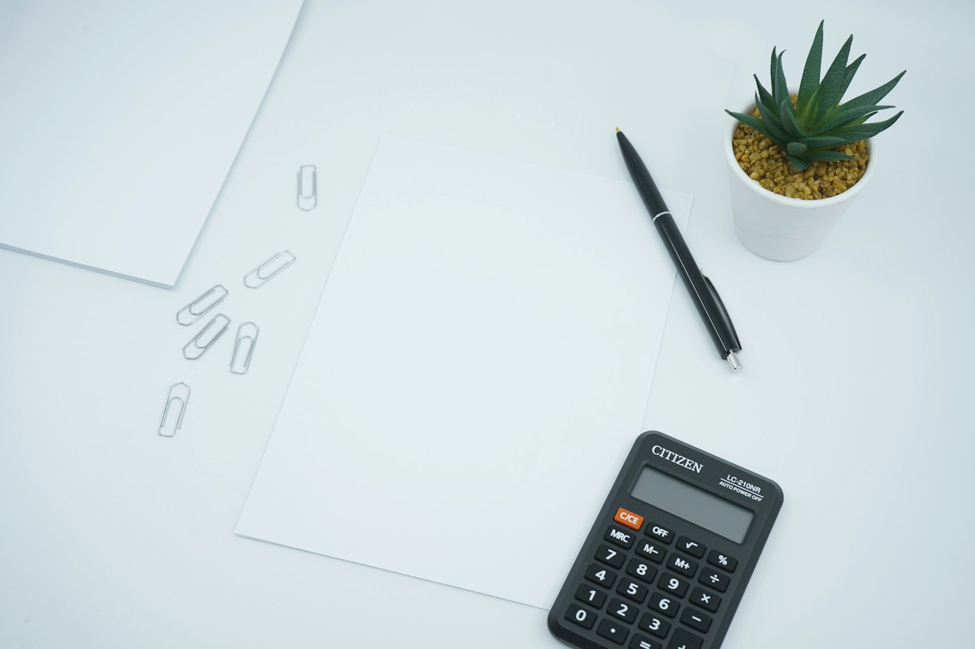 Bureau avec documents, stylo et calculatrice pour préparer une location courte durée