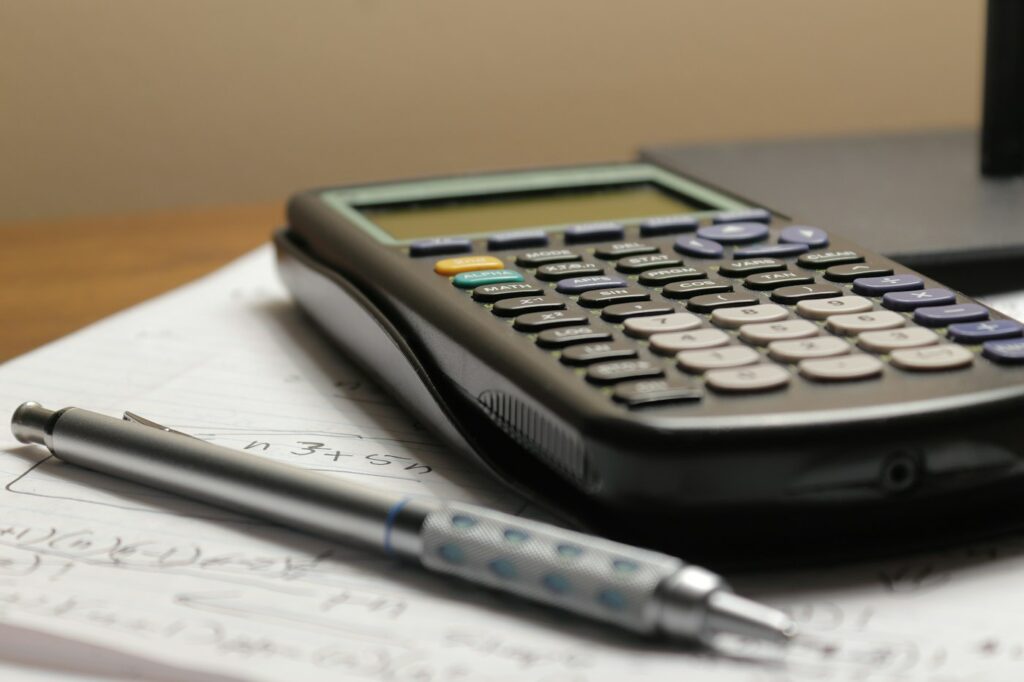 Calculatrice et stylo posés sur une déclaration de revenus de location meublée
