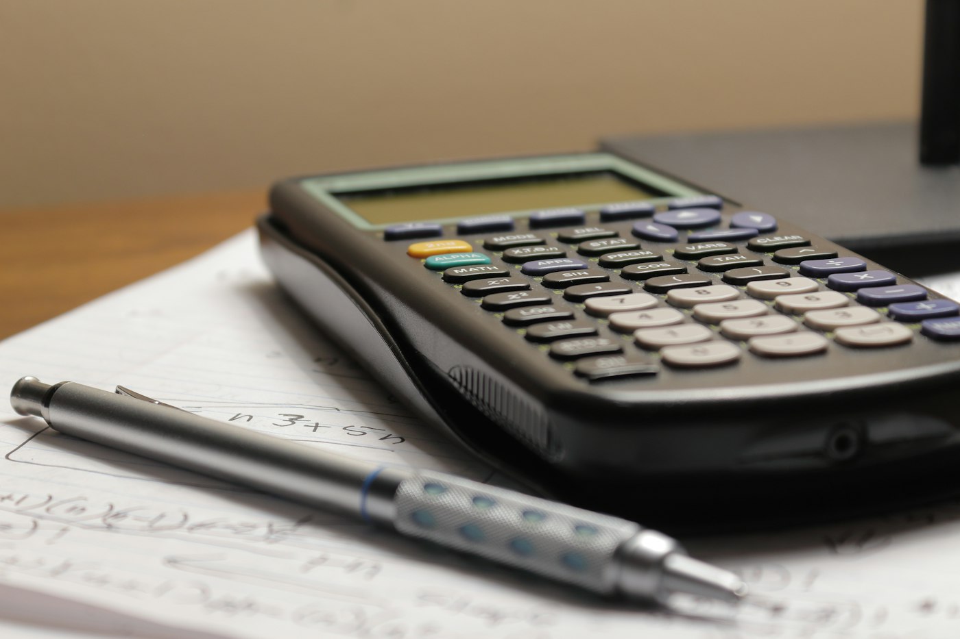 Calculatrice et stylo posés sur une déclaration de revenus de location meublée