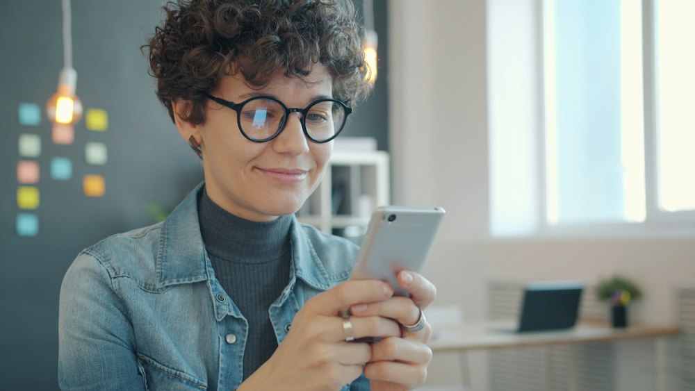 Propriétaire souriante consultant son téléphone
